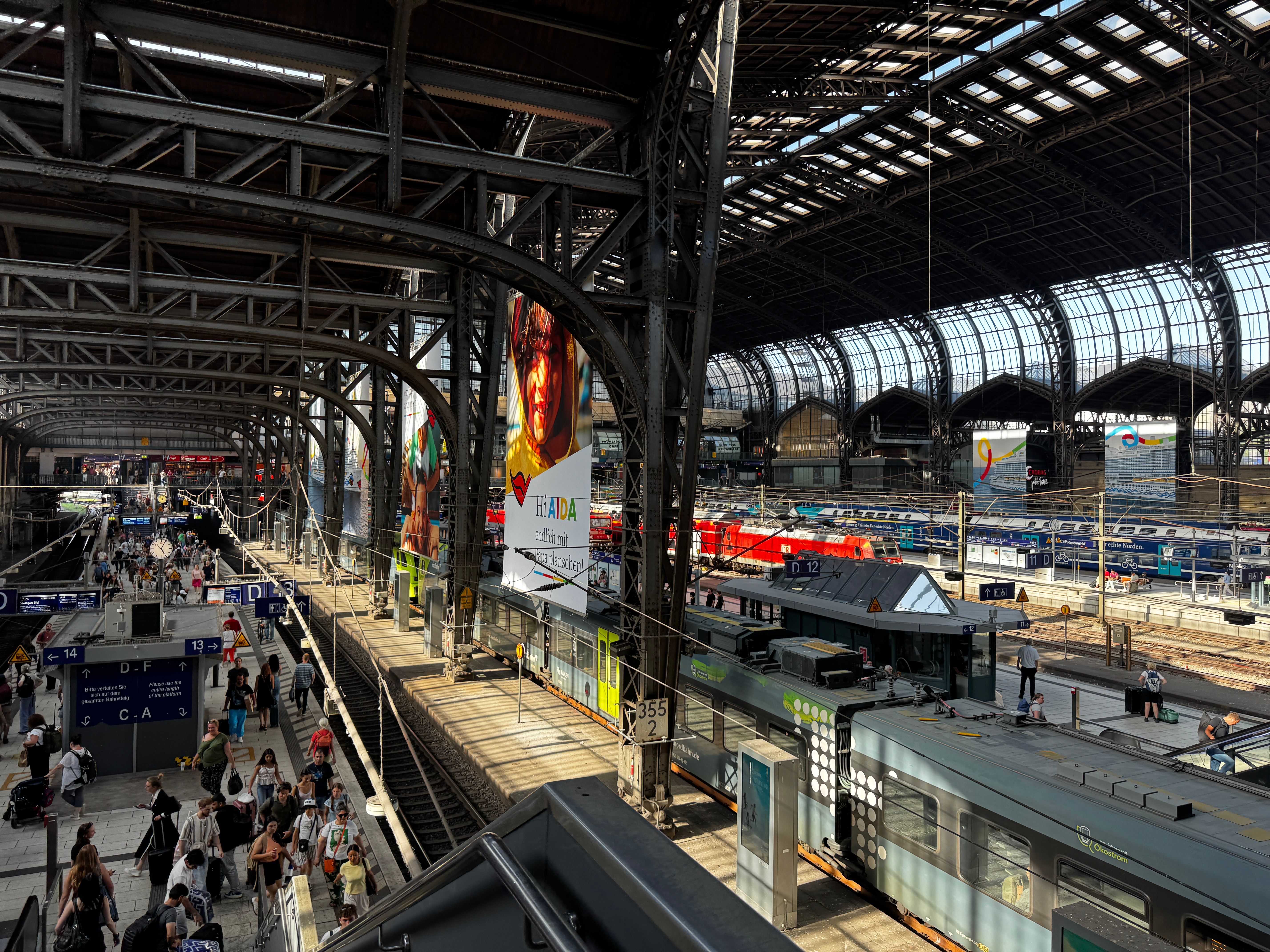 Passengers walk through Frankfurt Central Station as trains wait beneath the vaulted roof