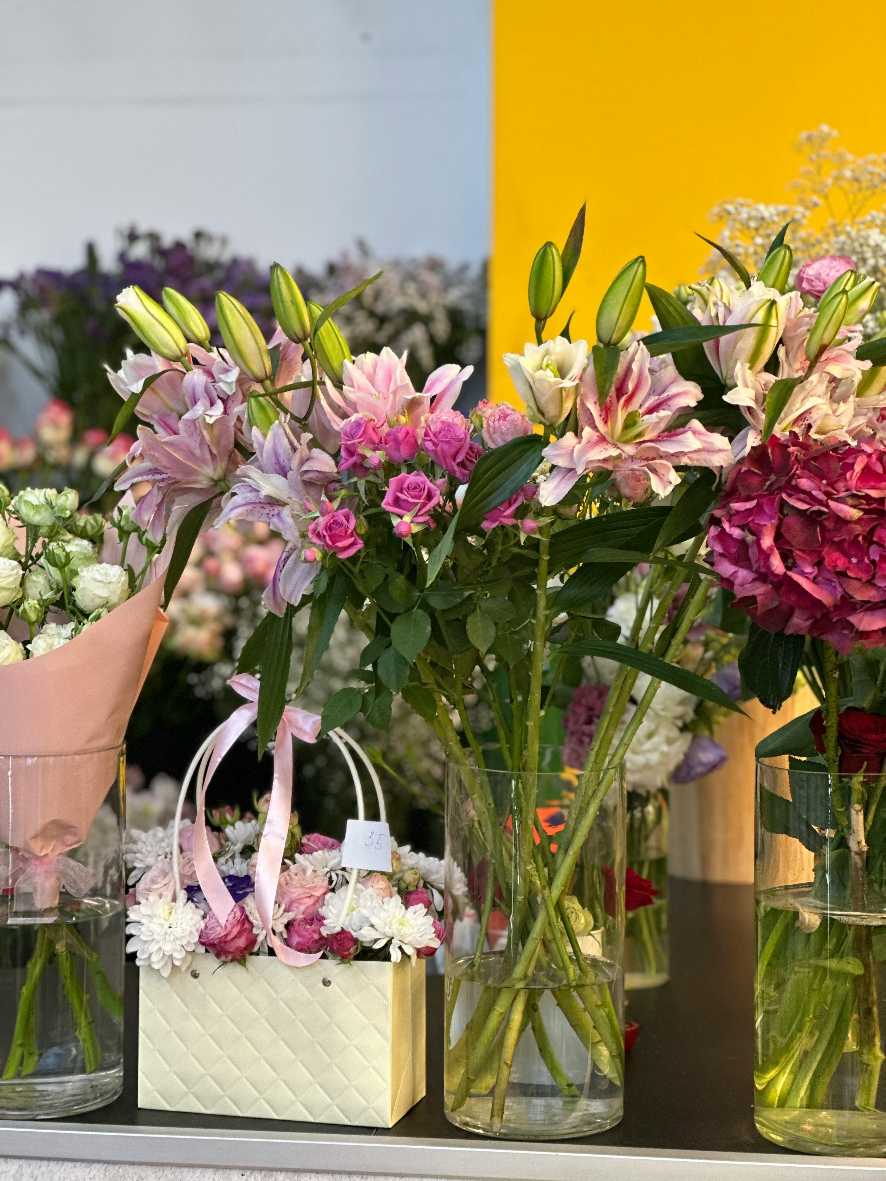 [ColoSach]-vibrant-display-of-pink-lilies-and-roses-in-glass-vases,-perfect-for-floral-enthusiasts.