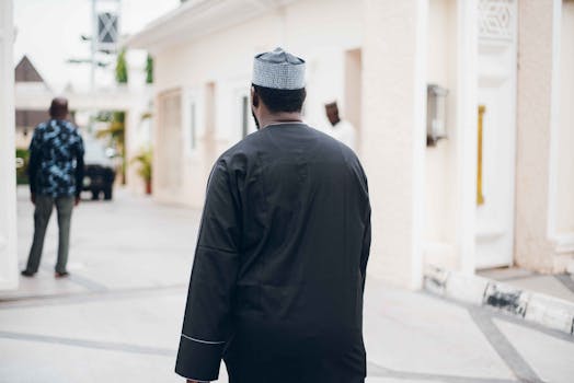 Men wearing traditional clothing walking outdoors on a sunny day.