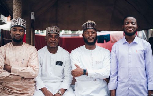 Free A diverse group of men wearing traditional and modern clothing, smiling together. Stock Photo