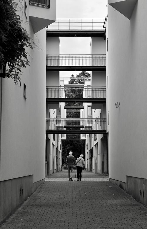 Free Black and white photo of a senior couple walking through modern buildings in Hamburg. Stock Photo