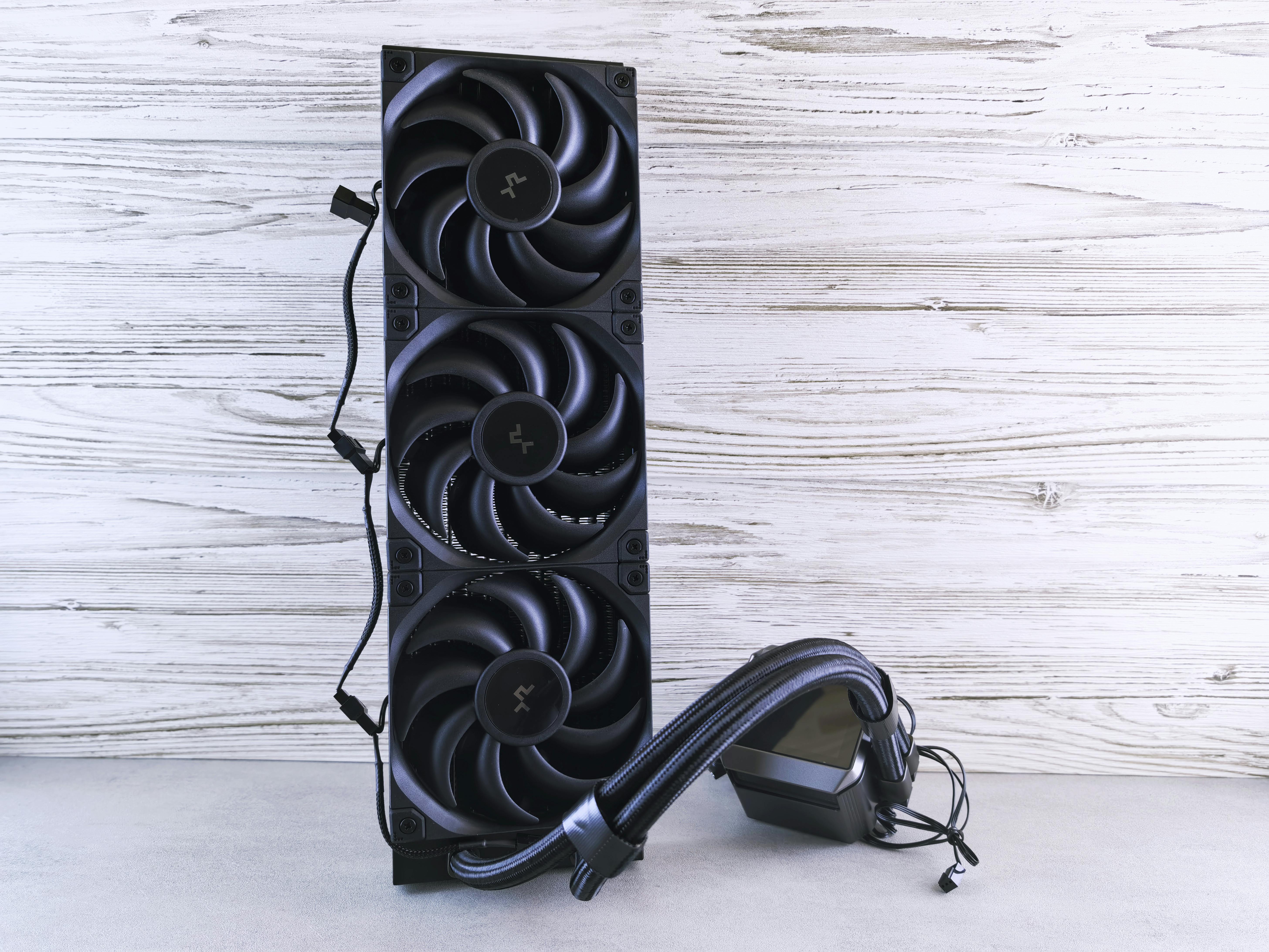 A triple fan radiator setup with cables, ideal for PC cooling solutions in a modern setting.
