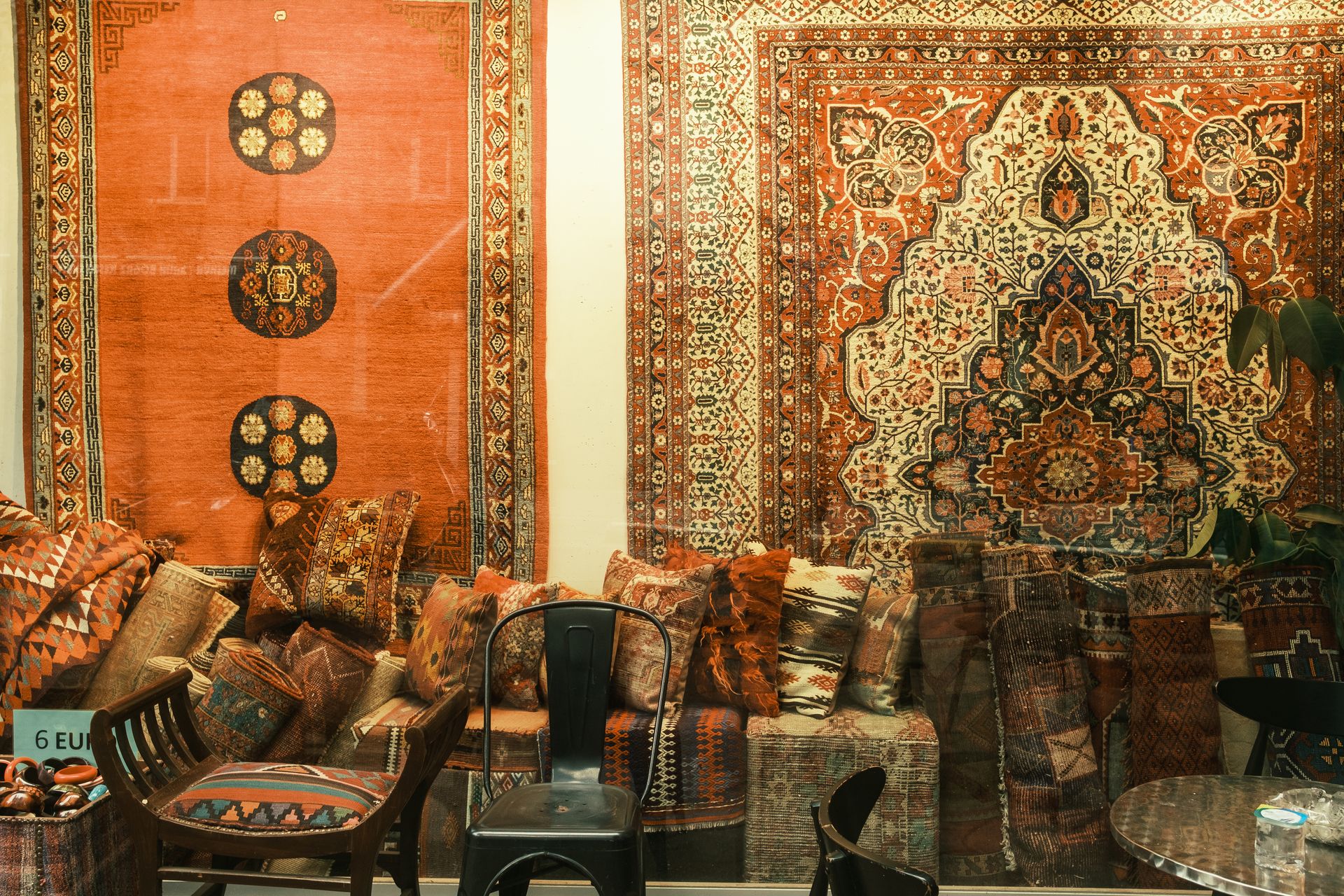 A vibrant display of traditional Persian rugs and patterned cushions in a cozy setting, perfect for decor inspiration.