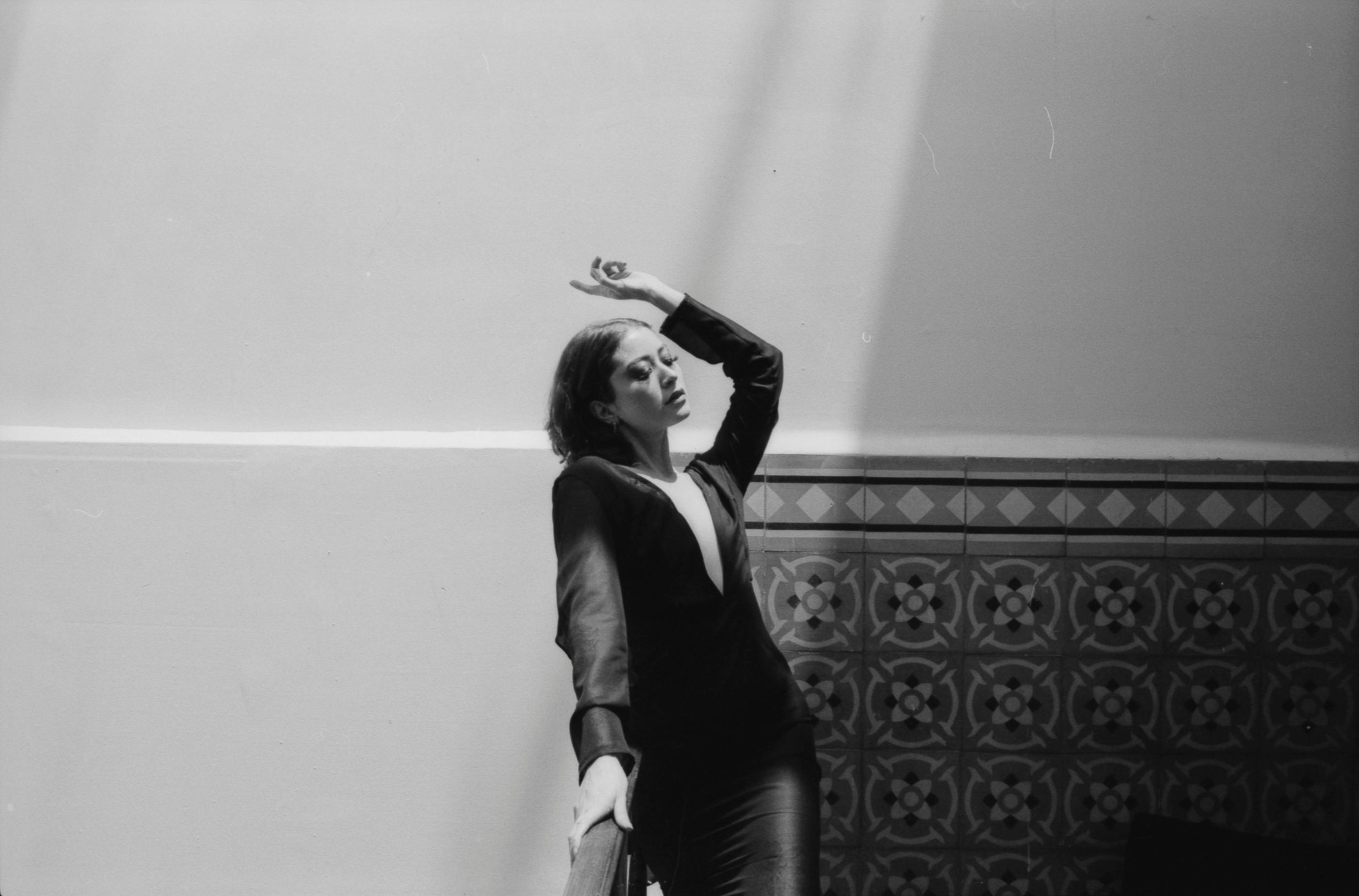 Gratis Splendido ritratto in bianco e nero di una donna in posa elegante in un interno con sfondo piastrellato. Foto a disposizione