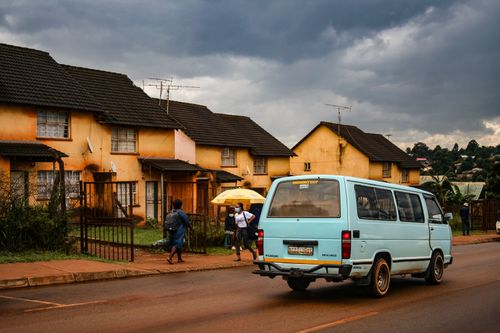 Free Typical street overcast day in Eswatini with a blue van and residential houses. Stock Photo