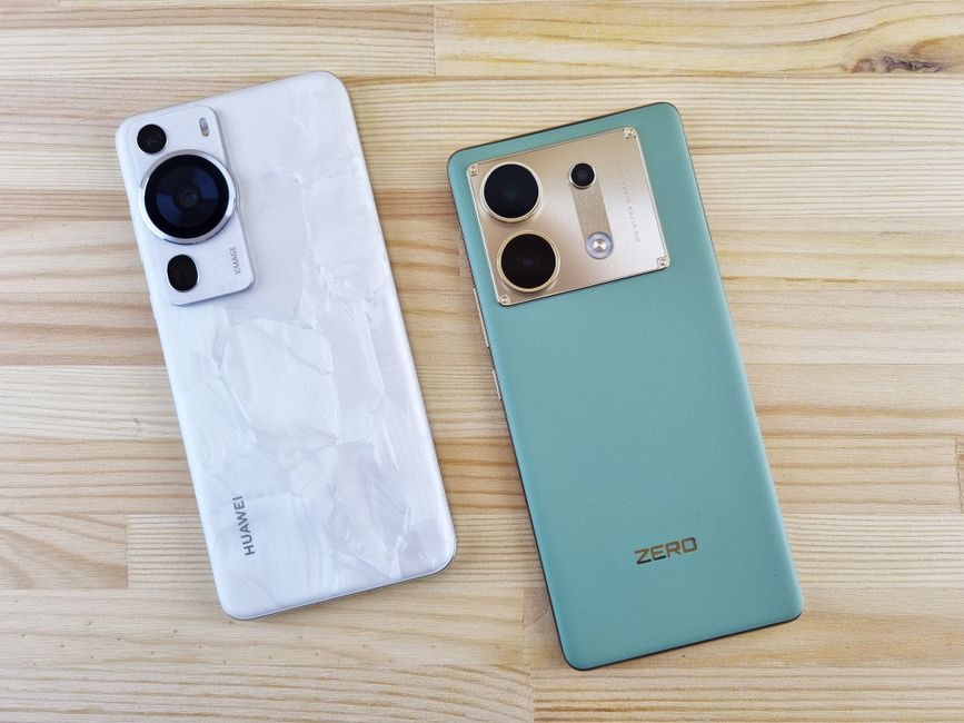 木のテーブルの上に置かれた二つの現代的なスマートフォンのクローズアップ、デザインと色のコントラスト。