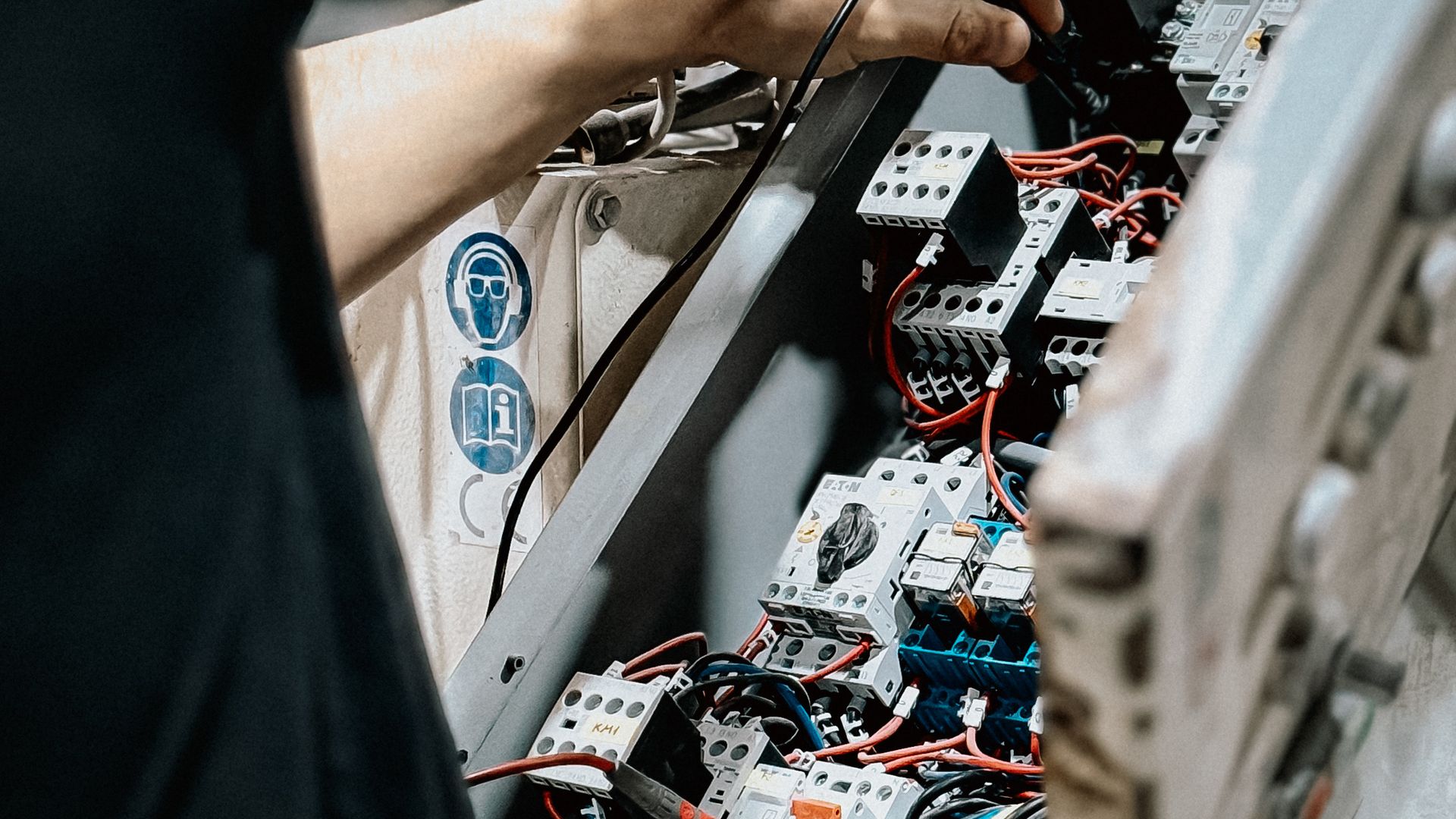 Safe NT technician testing and tagging electrical equipment in a switchboard