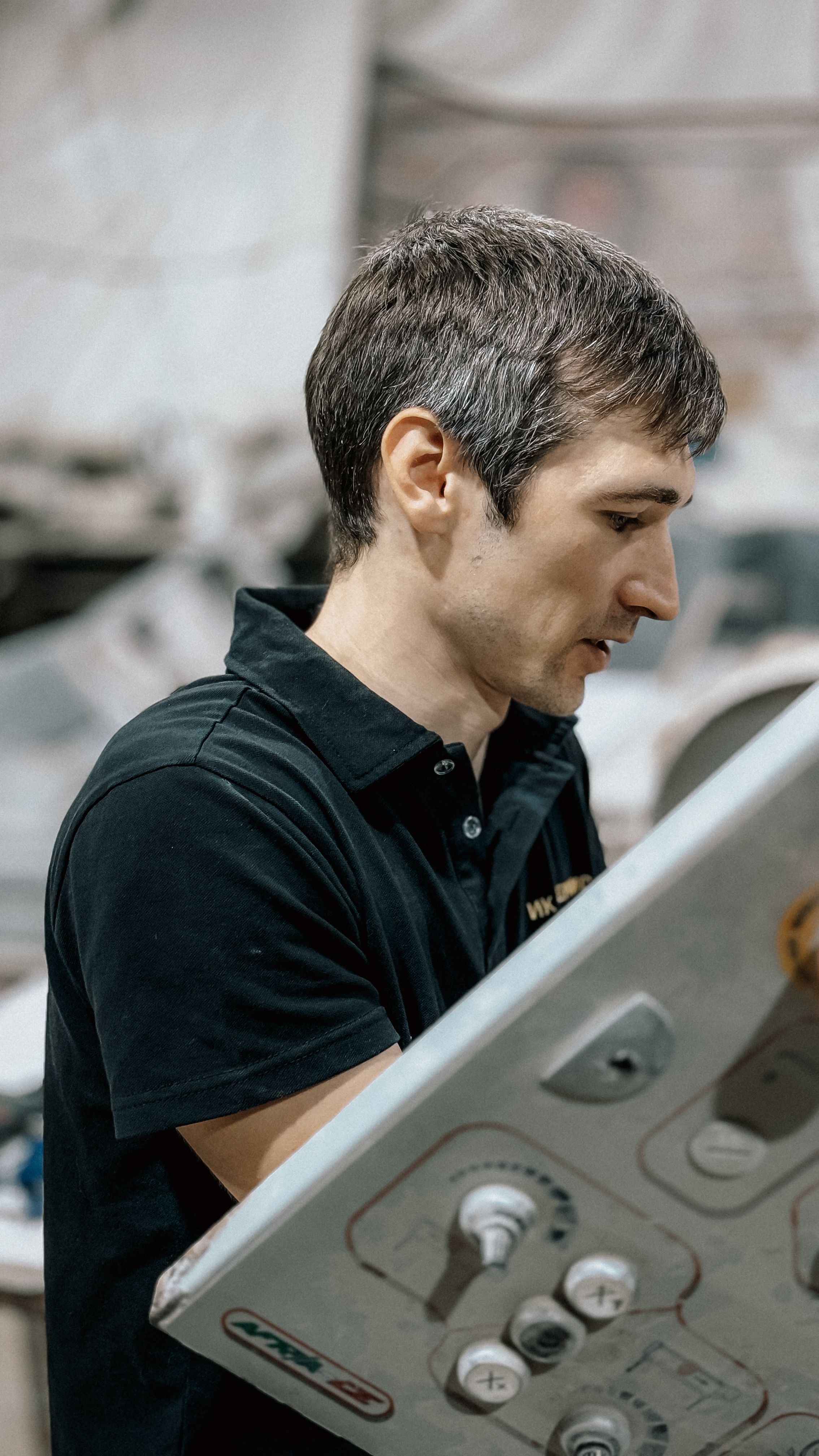 Gratis Un uomo concentrato che utilizza un pannello di controllo in un ambiente di fabbrica, che mostra il lavoro industriale. Foto a disposizione
