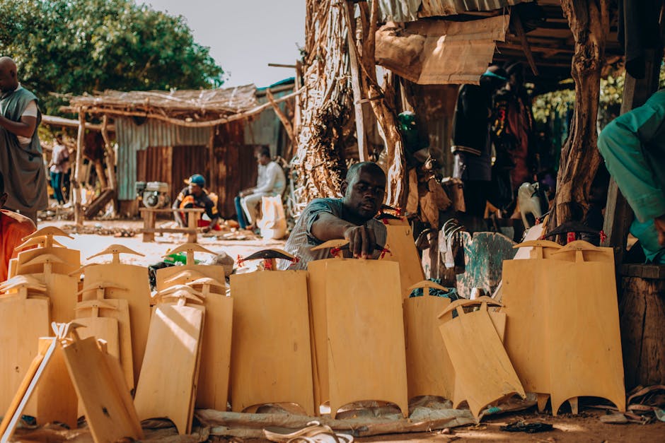 Skilled artisans handcraft traditional Nigerian items in a vibrant outdoor market setting, showcasing cultural craftsmanship.