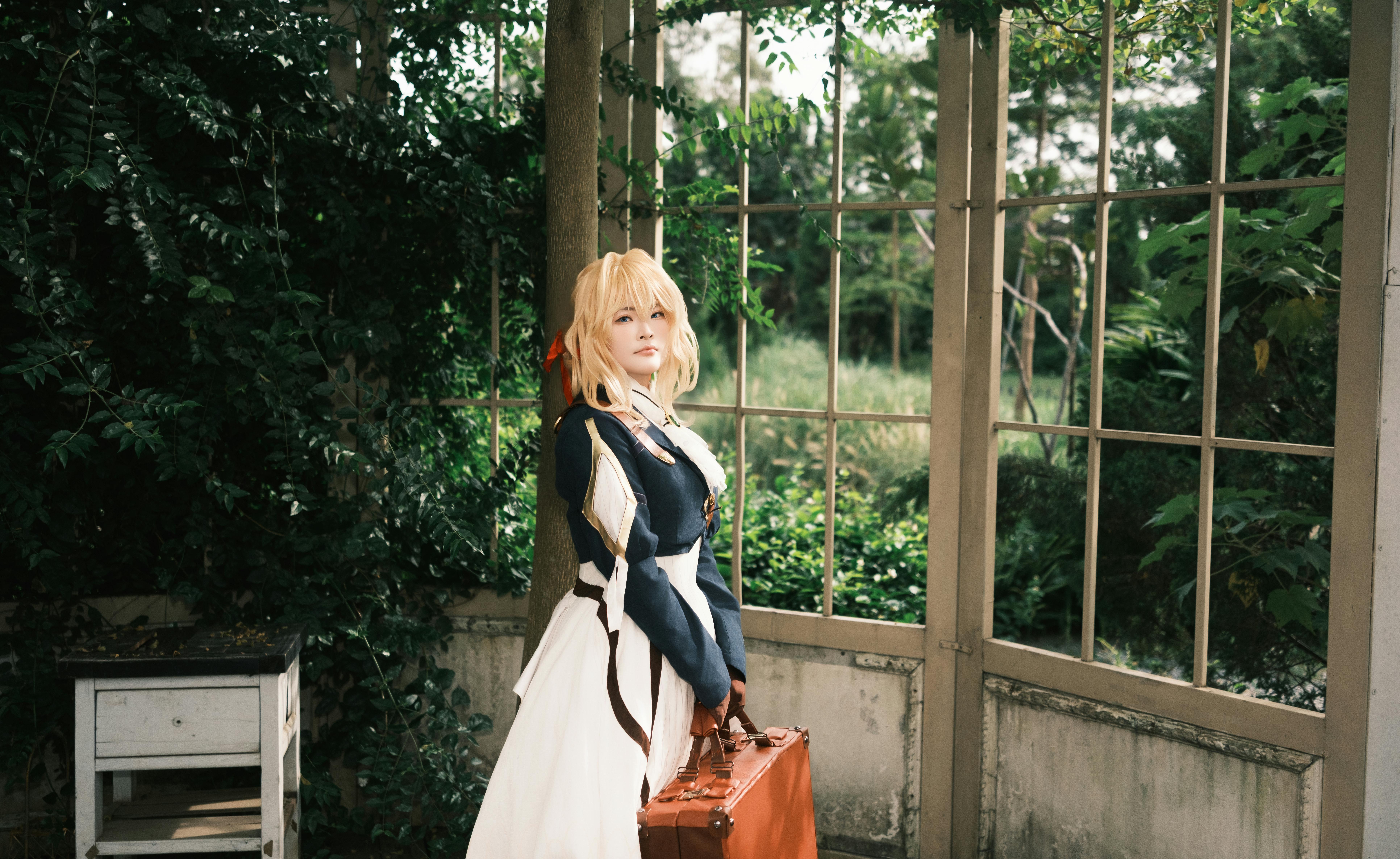 A cosplayer dressed as a character in a tranquil garden environment.