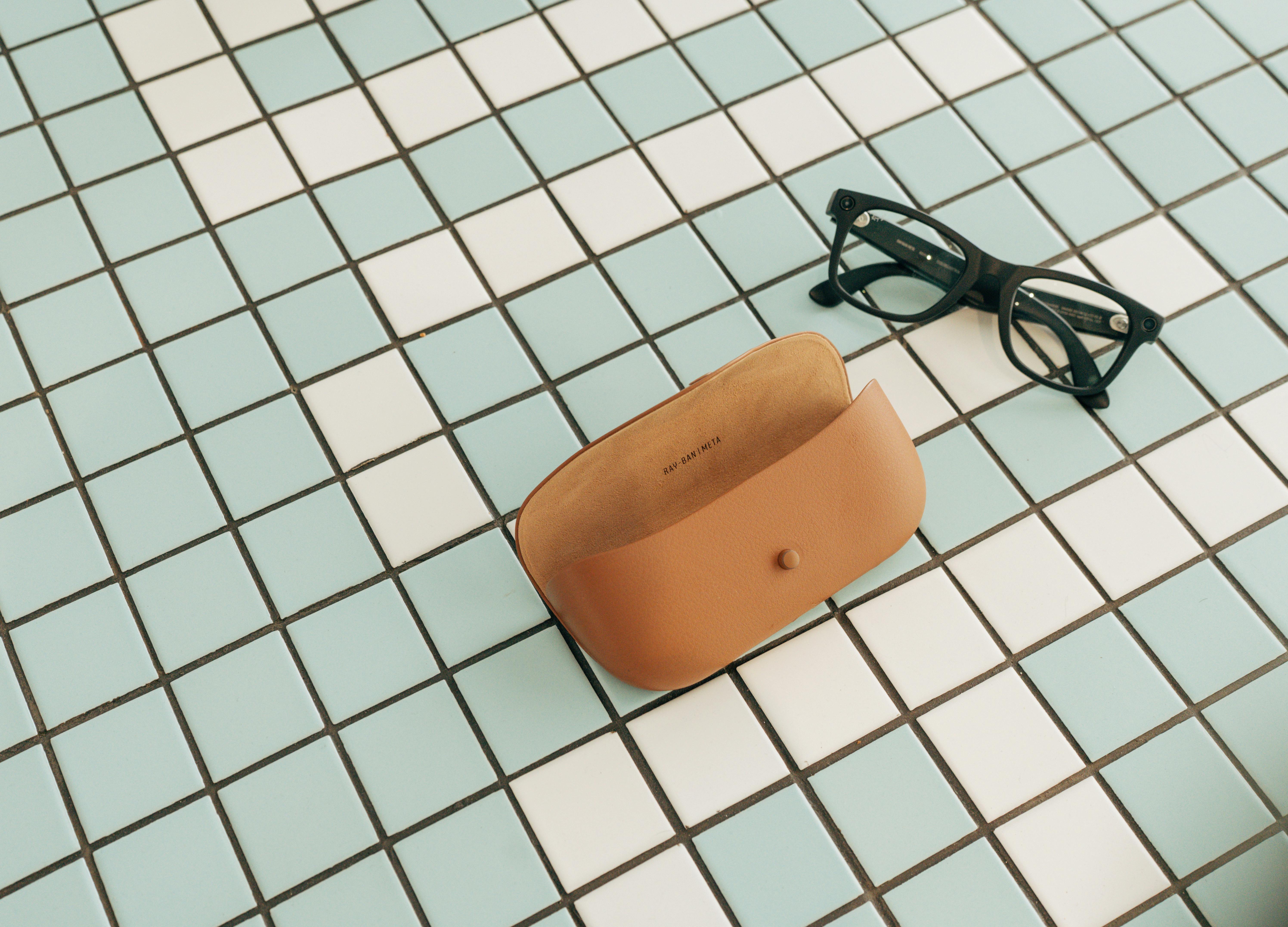 gratis Een bril en een leren etui op een stijlvolle achtergrond van geblokte tegels. Stockfoto