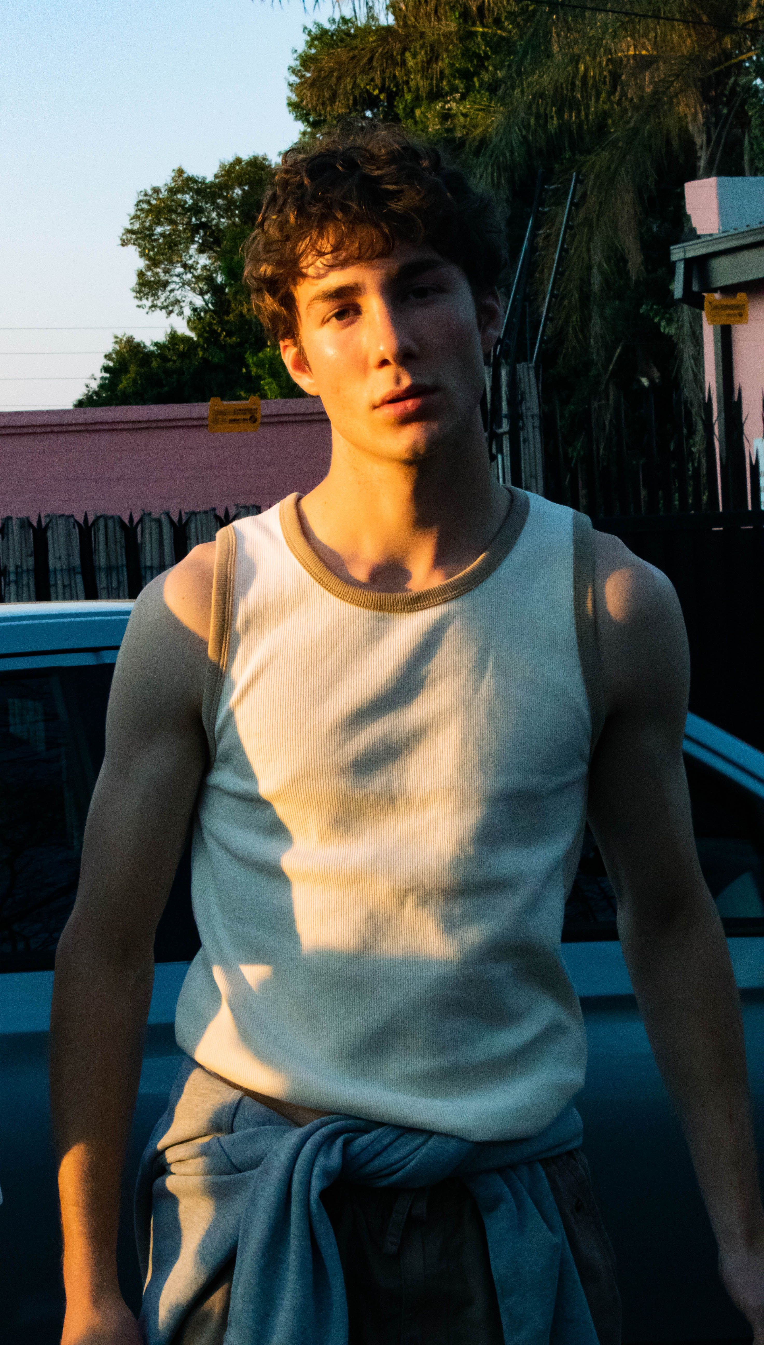 Casual portrait of a young man in urban setting during golden hour.