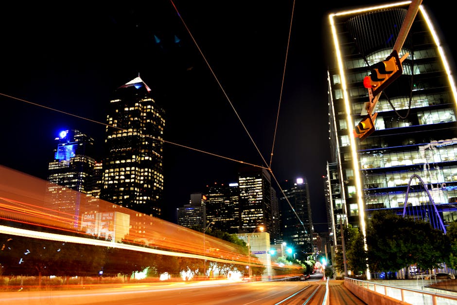 Dynamic night view of Dallas skyline with light trails capturing urban energy and modern architecture.
