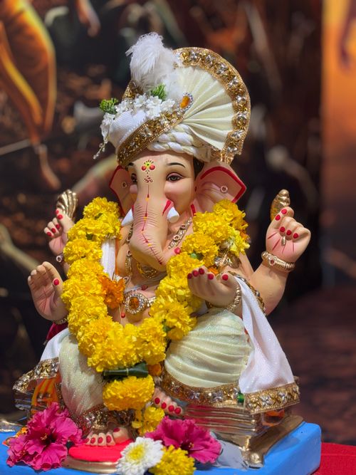Free Colorful statue of Lord Ganesha adorned with a floral garland and intricate attire. Stock Photo
