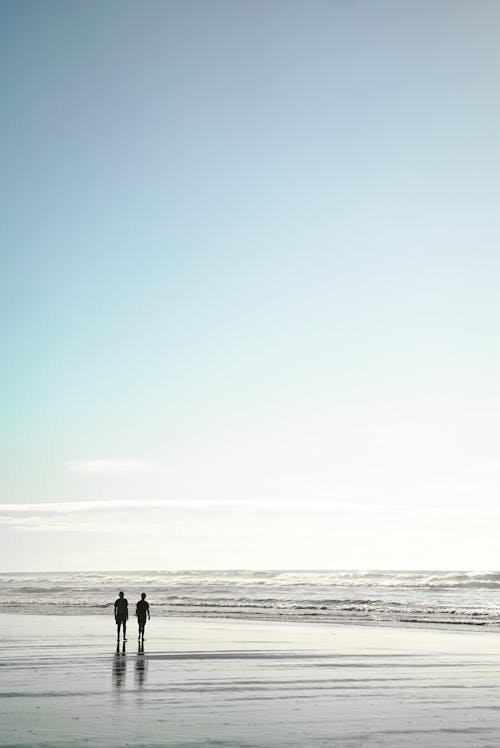 Two People Standing on Seashore