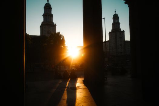 Capture of a sunset silhouetting two towers in Berlin, highlighting the city's modern architecture.