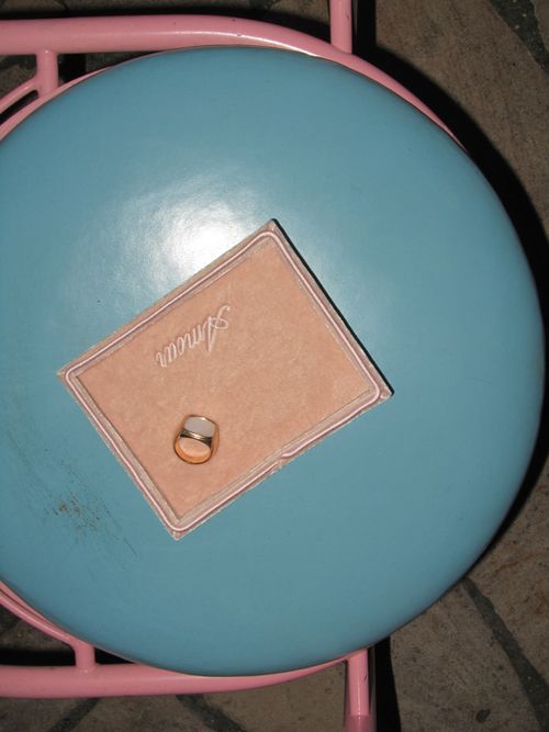 Free Elegant minimalist ring displayed atop a pink-bordered blue round stool for a unique, stylish presentation. Stock Photo