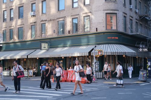 Free People crossing the street near Jack's Wife Freda cafe on a sunny day. Stock Photo