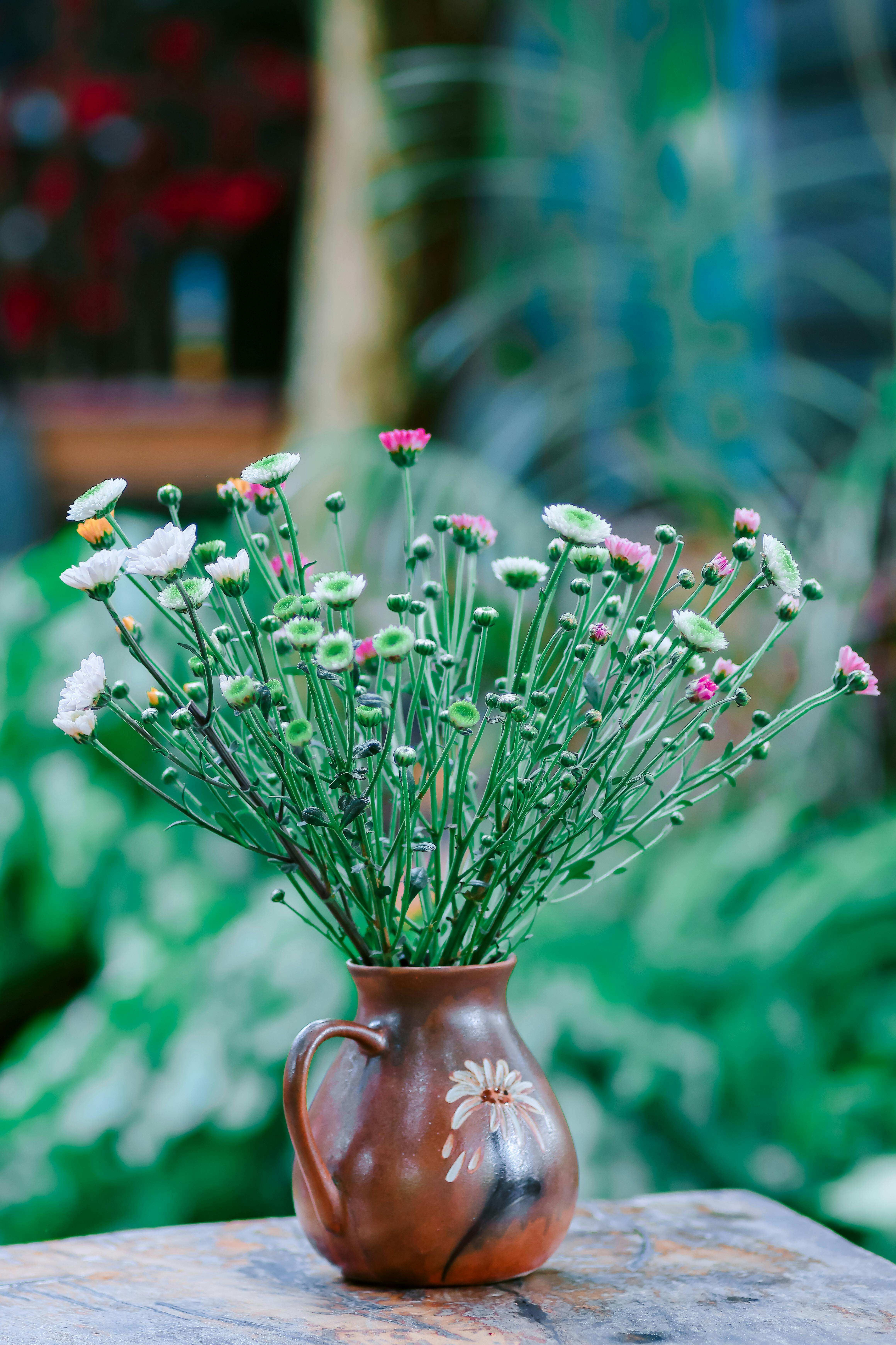 [ColoSach]-colorful-wildflowers-in-a-rustic-vase-set-against-a-blurred-outdoor-background.