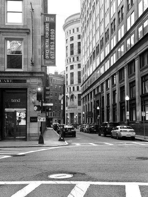 Free Black and white photo of a city street in Boston's financial district, featuring historic buildings. Stock Photo