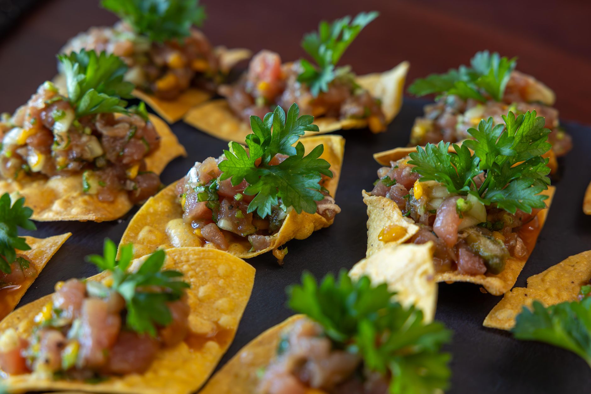 Tasty nachos topped with fresh salsa and herbs, perfect for parties or appetizers.
