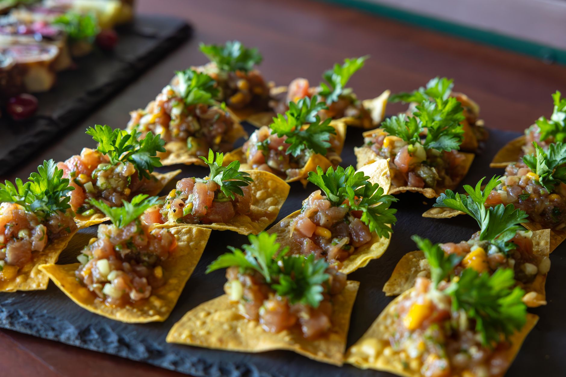 Delicious corn tortilla chips topped with fresh salsa and parsley, perfect appetizer for parties.