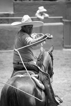 A charro performs a traditional roping skill during a charrería event in Tlaxcala, Mexico.
