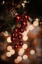 特写镜头中，树上的红色圣诞装饰品以温暖的散景为背景，唤起了节日气氛