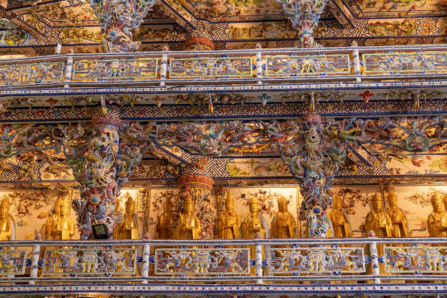 Marvel at the intricate details of this Buddhist temple's ornate interior, showcasing golden statues and vivid decoratio