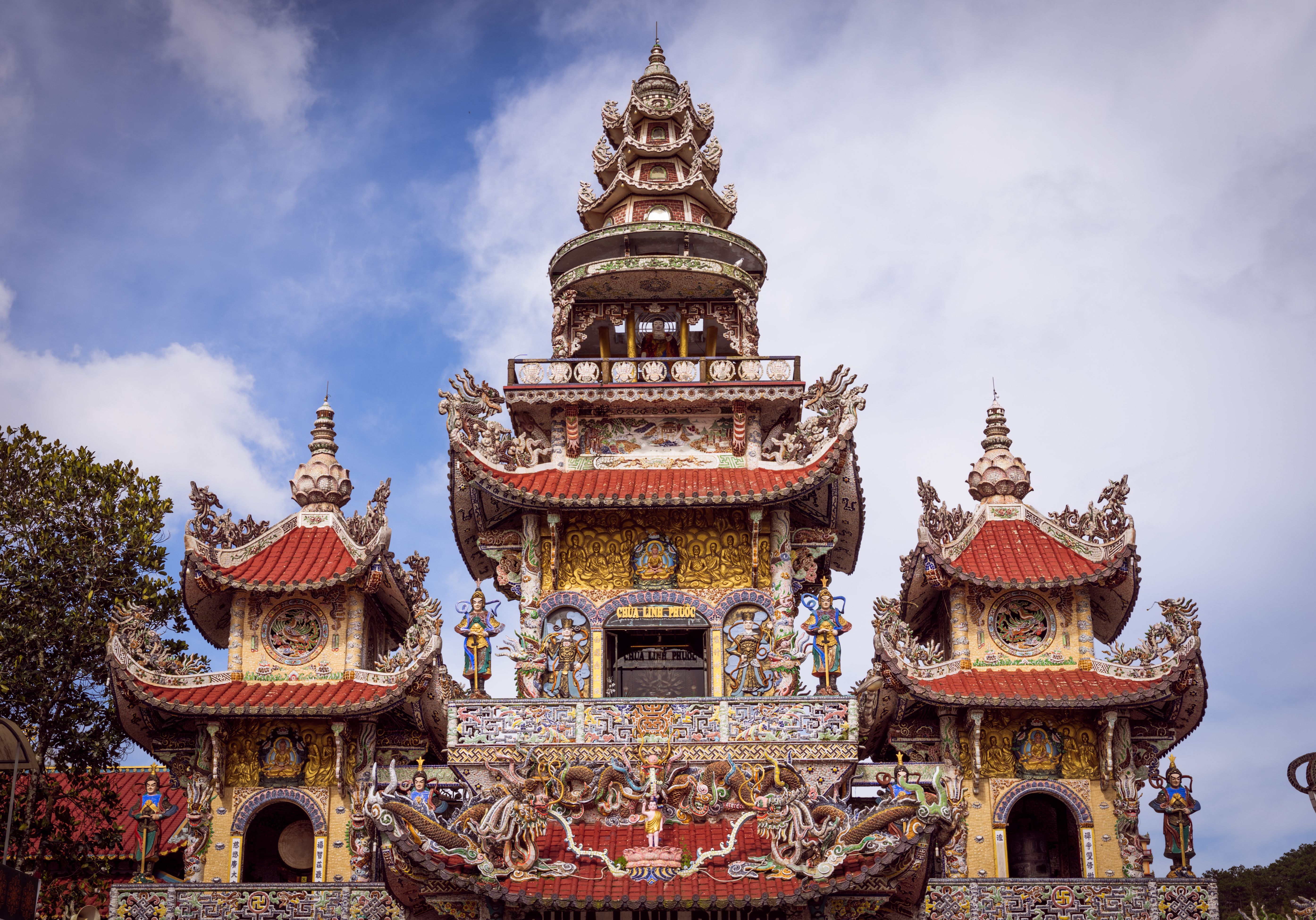 A detailed view of intricate pagoda architecture under a clear blue sky, showcasing vibrant colors and design.