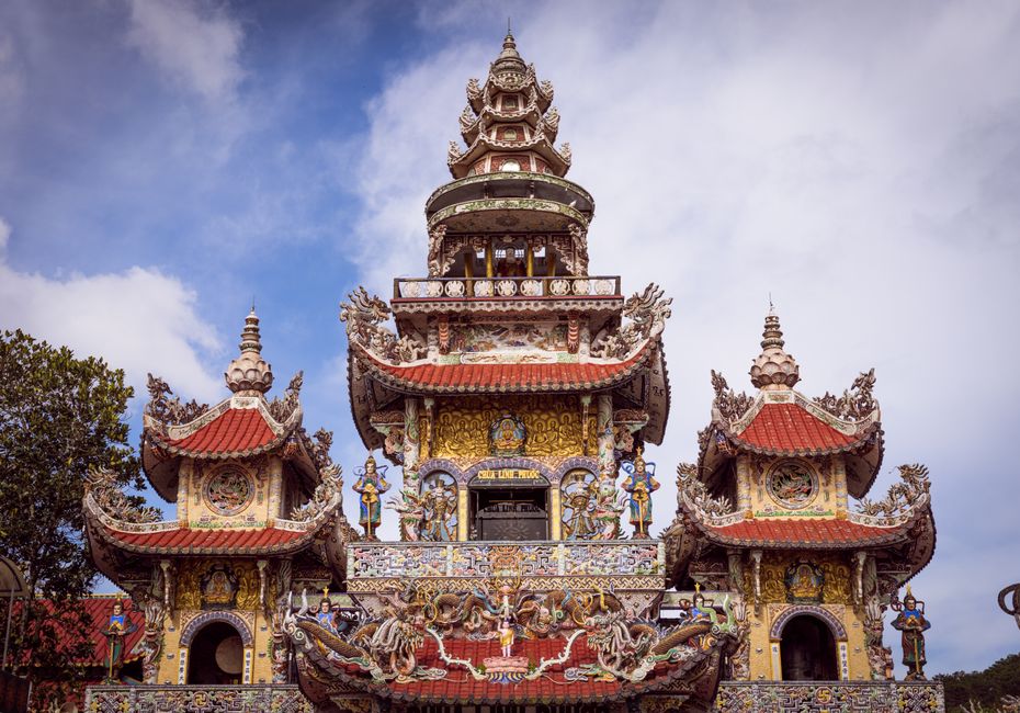 A detailed view of intricate pagoda architecture under a clear blue sky, showcasing vibrant colors and design.