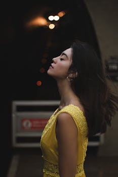 一位身着黄色连衣裙的女性，以散景为背景，在时尚肖像中散发着优雅与自信