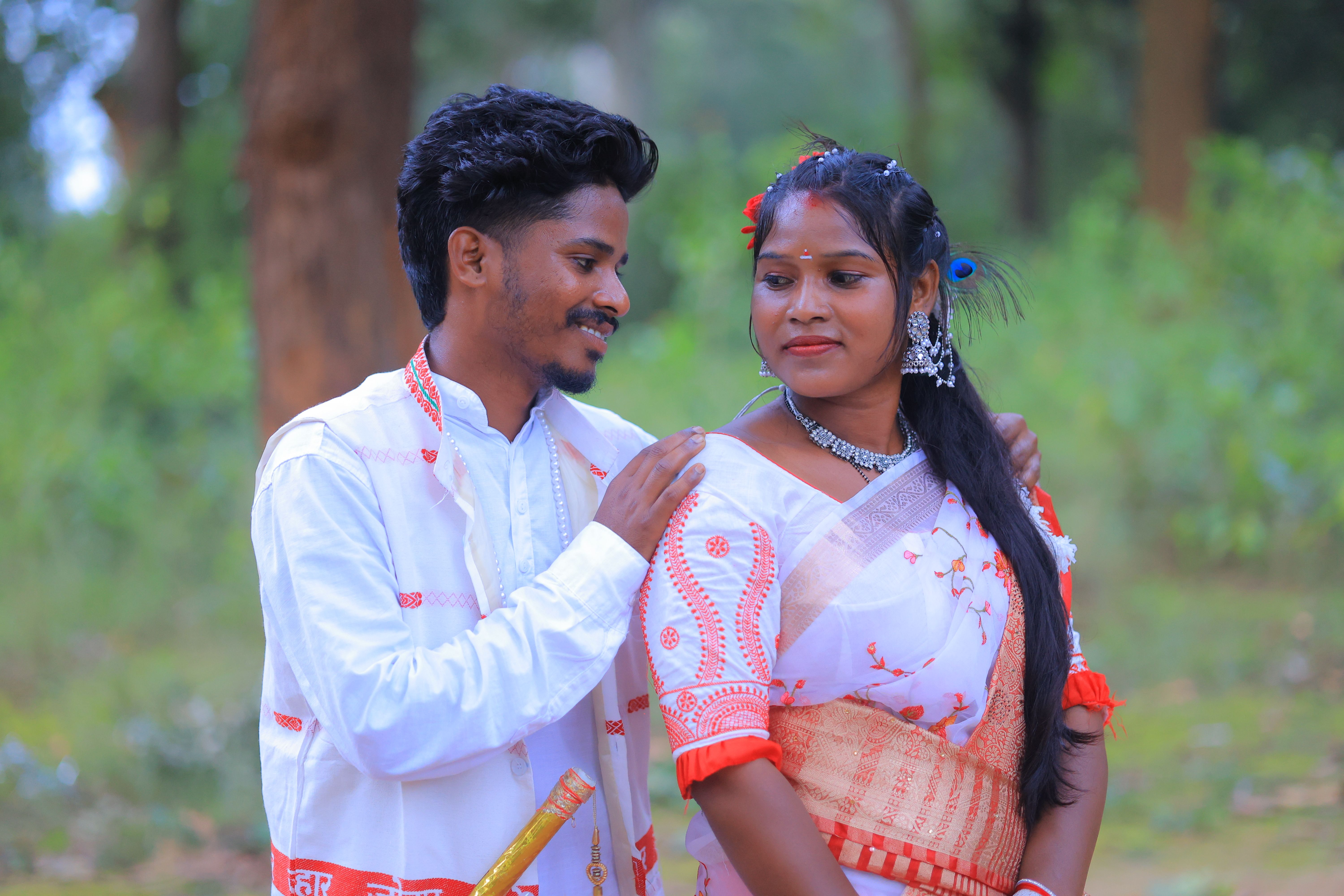 A couple in traditional Indian attire enjoying a serene outdoor setting.