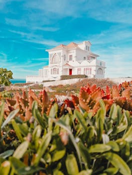 Beautiful Mediterranean-style villa with lush succulents under a clear blue sky.