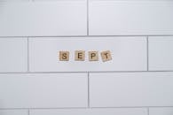 Wooden Blocks Spell 'Sept' on Tiled Wall