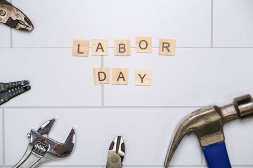 Free Labor Day themed image with tools and Scrabble tiles spelling 'Labor Day'. Stock Photo