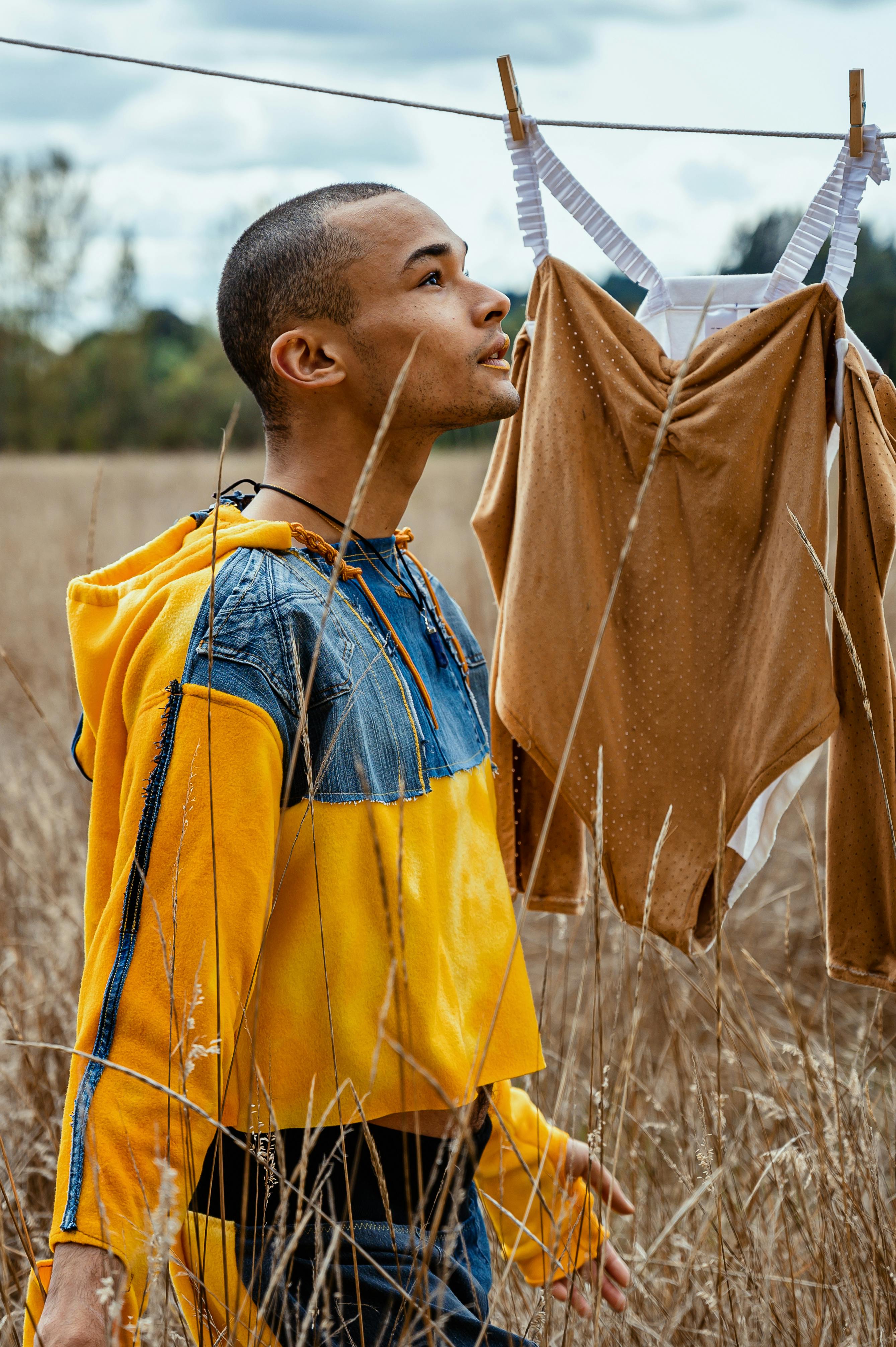 Man Wearing Yellow and Blue Jacket Standing on Brown Field · Free Stock