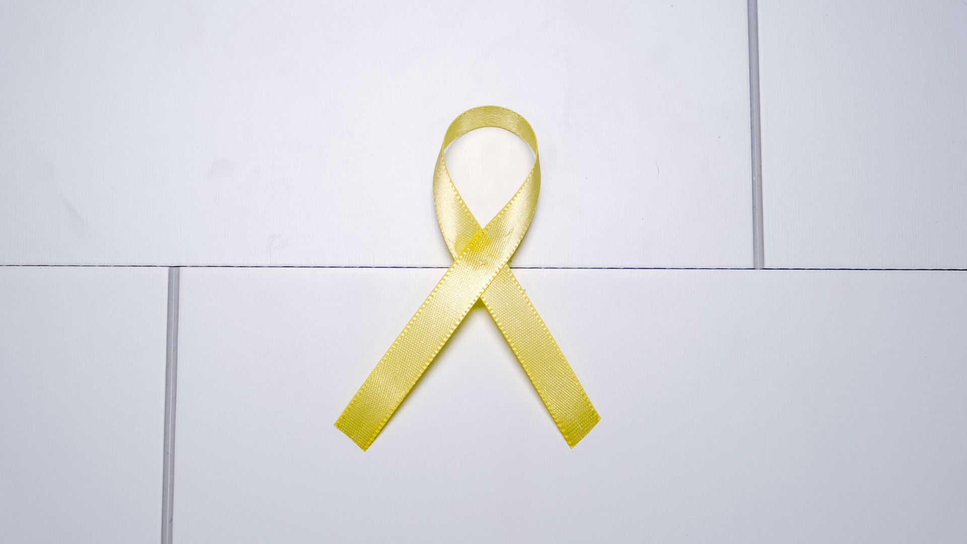 Modafinil for Cancer Related Fatigue: Unlocking Energy Yellow ribbon on white tiles symbolizing awareness and support across various causes — modafinil for cancer related fatigue