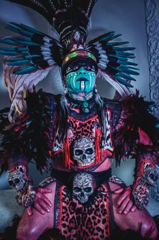 Portrait of a person in traditional indigenous ceremonial attire with feathers and makeup. - Fotografer Sidoarjo