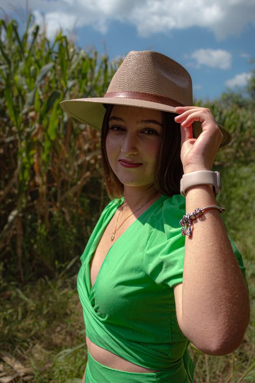 Free Woman wearing a green dress and hat in a sunny field in Santiago de Querétaro, Mexico. Stock Photo