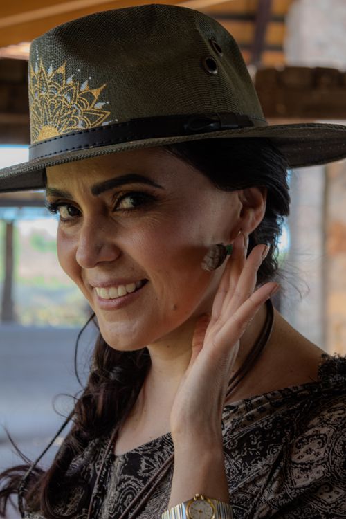 Free Close-up portrait of a woman wearing a stylish hat and earrings, captured indoors in Santiago de Querétaro, México. Stock Photo