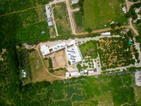 Explore the lush greenery and architectural layout in Ajrakhpur, Gujarat from above.