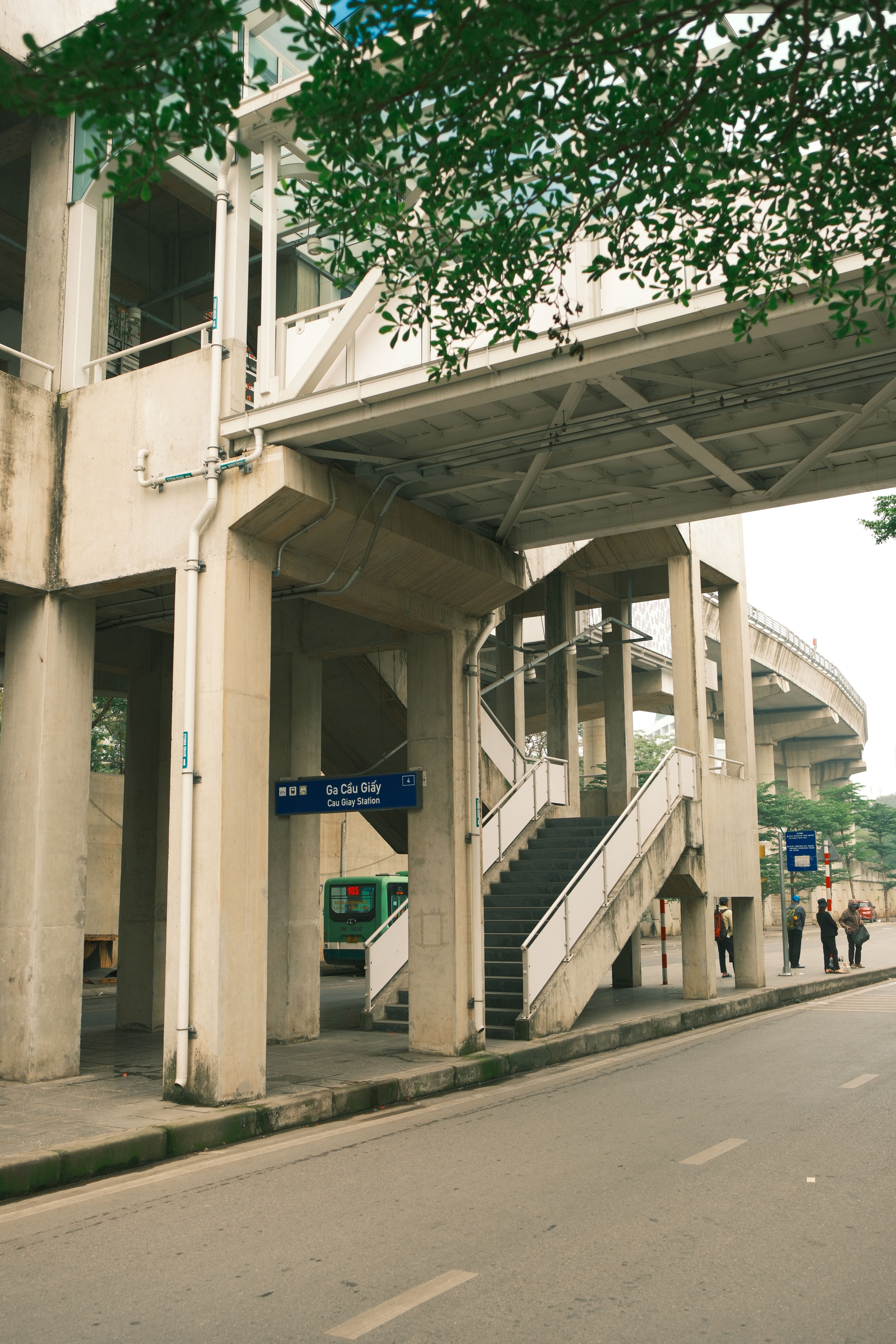 A contemporary metro station in an urban setting with visible signage and people.