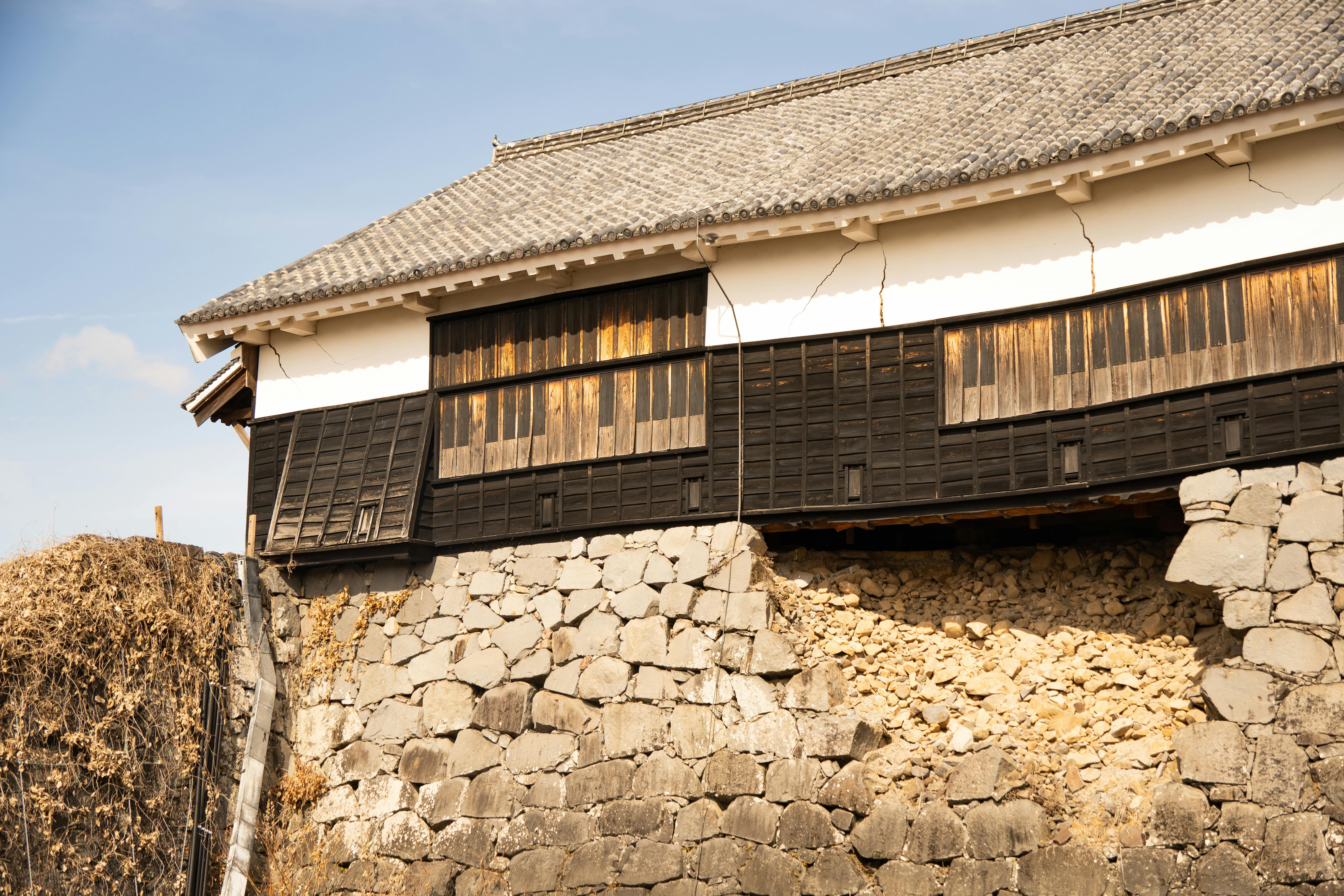 Aged stone wall of Kumamoto Castle with its iconic traditional architecture, Japan.