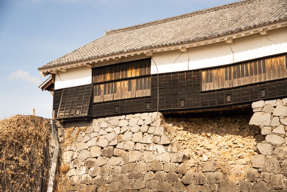 Aged stone wall of Kumamoto Castle with its iconic traditional architecture, Japan.