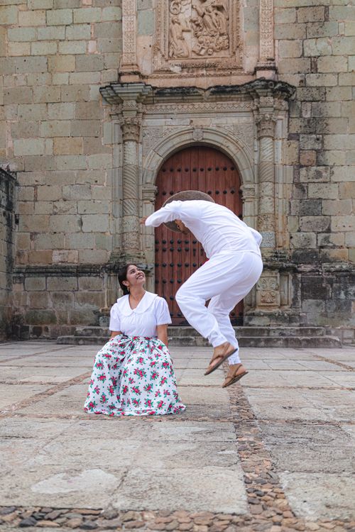 Free A vibrant dance performance in front of a historic building showcasing cultural attire. Stock Photo