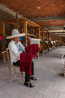 Artisan at a wooden handloom in a workshop, photo by Walter Alejandro on Pexels