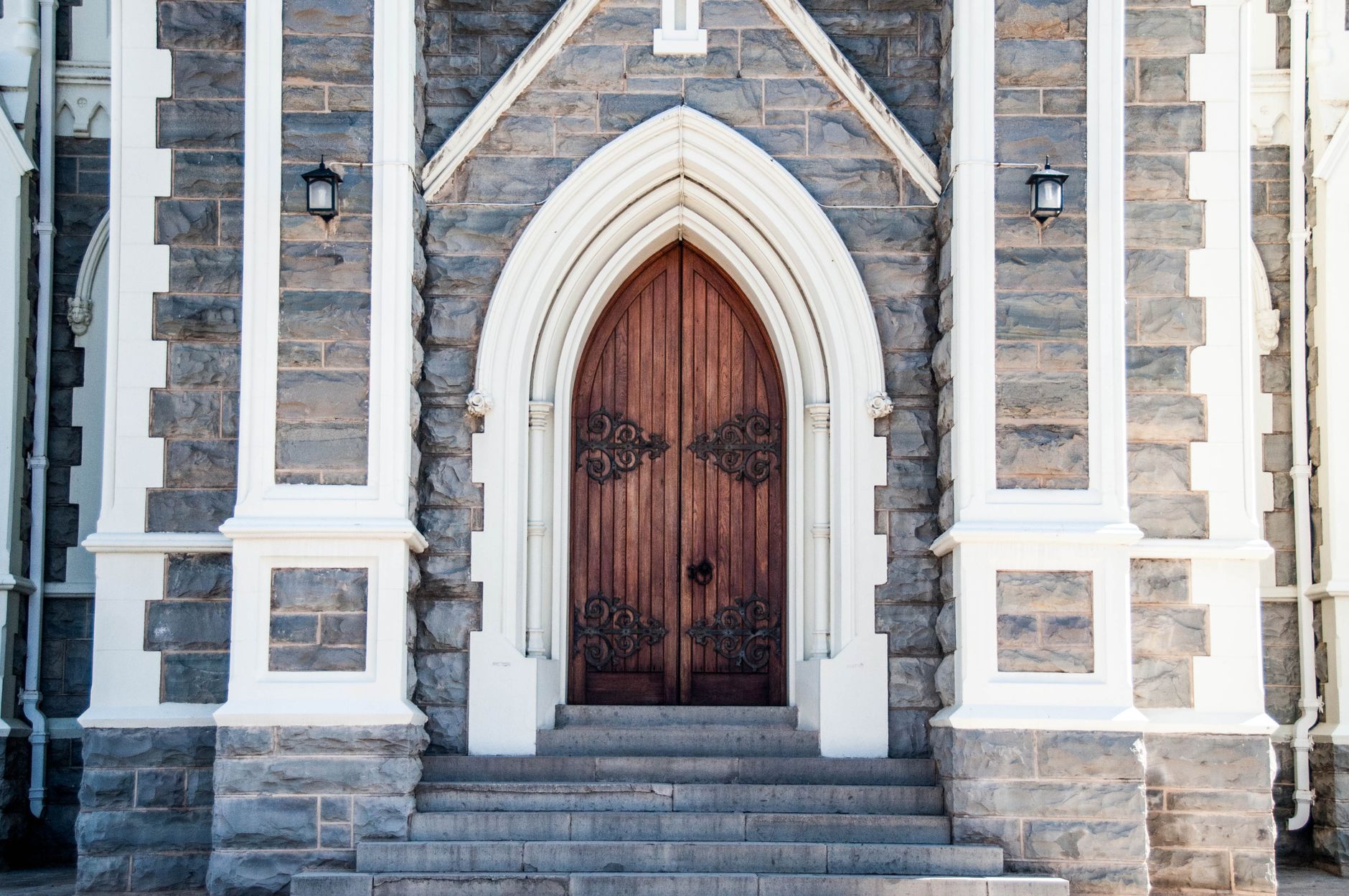 Entrée d'une église gothique en pierre, avec de somptueuses portes en bois à arcade, en Afrique du Sud.