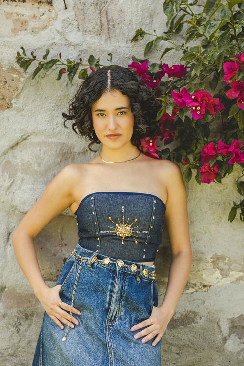 Free Stylish young woman in denim, posing against a floral-decorated wall in Santiago de Querétaro. Stock Photo
