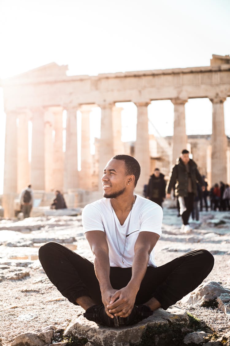 Man Sitting On Rock